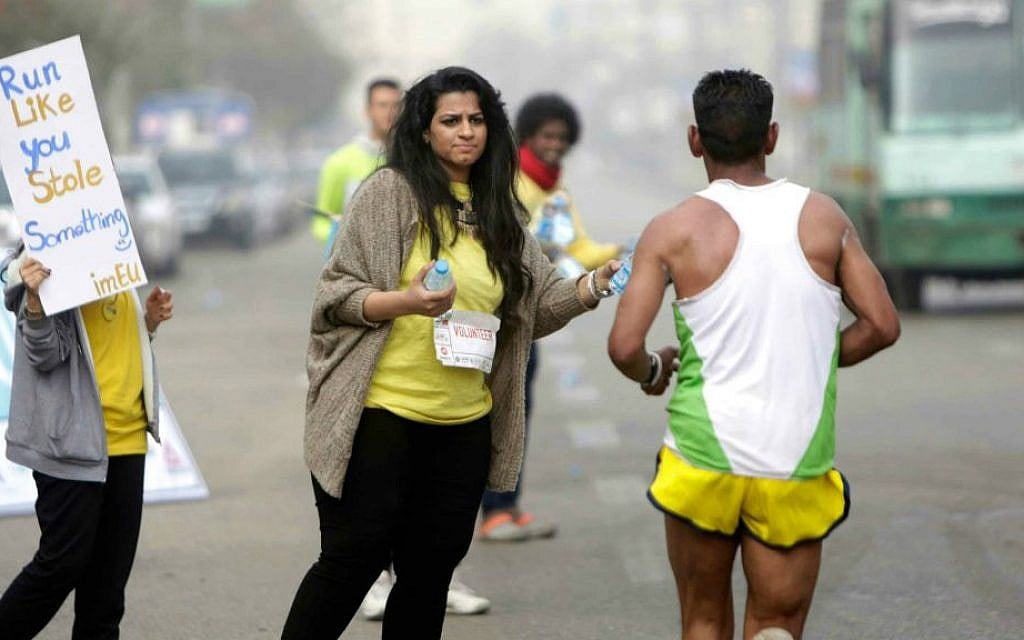 In this Friday, April 17, 2015 photo, Egyptian volunteers at a water stop offer water to runners participating in Cairo's annual Half Marathon in the Heliopolis district in Cairo, Egypt. (AP Photo/Amr Nabil)