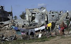 A Palestinian woman hangs washing next to the rubble of her destroyed house, in the Shijaiyah neighborhood of Gaza City, Monday, March 30, 2015.  (AP/Khalil Hamra)