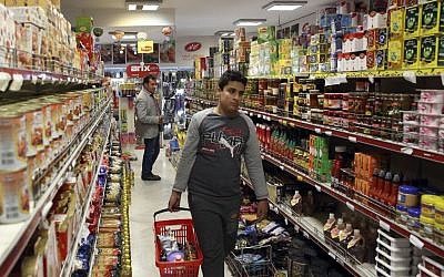 Iranians shop in a supermarket in north Tehran, Iran, April 29, 2015. Iran has removed the country's wealthiest citizens off a list of people receiving monthly handouts in a small step toward easing the burden on the budget and freeing up more government funds. (Photo credit: Vahid Salemi/AP)