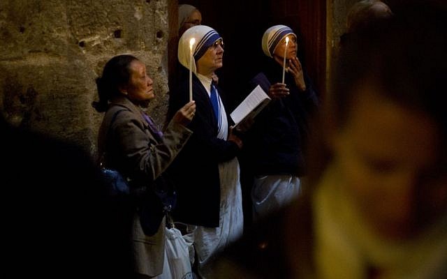 Christian women and nuns pray in the Church of the Holy Sepulcher, traditionally believed by many to be the site of the crucifixion and burial of Jesus Christ, during Orthodox Palm Sunday, in Jerusalem, Sunday, April 5, 2015. (photo credit: AP/Ariel Schalit)
