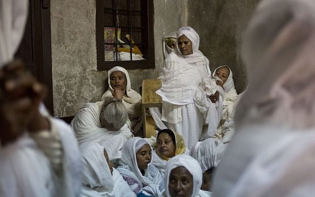 Ethiopian Orthodox Christian women pray at Deir El Sultan outside the Church of the Holy Sepulcher, traditionally believed by many to be the site of the crucifixion and burial of Jesus Christ during Orthodox Palm Sunday, in Jerusalem, Sunday, April 5, 2015. (photo credit: AP/Ariel Schalit)