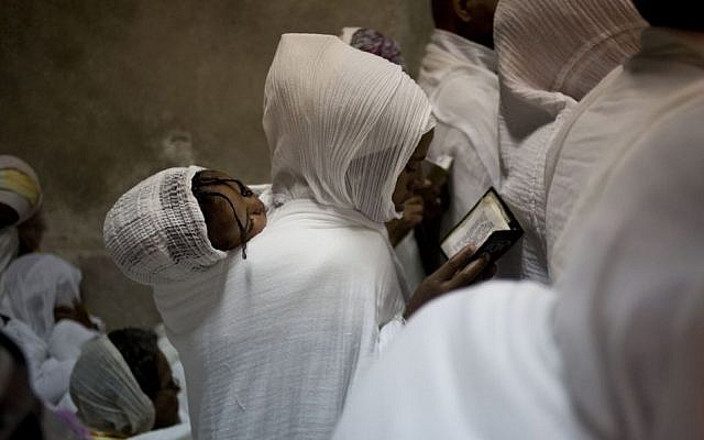 Ethiopian Orthodox Christian women pray at Deir El Sultan outside the Church of the Holy Sepulcher, traditionally believed by many to be the site of the crucifixion and burial of Jesus Christ, during Orthodox Palm Sunday, in Jerusalem, Sunday, April 5, 2015. (photo credit: AP/Ariel Schalit)