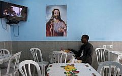 An African migrant sits at a restaurant in Tel Aviv, Israel, Tuesday, April 21, 2015. (Photo credit: AP/Oded Balilty)