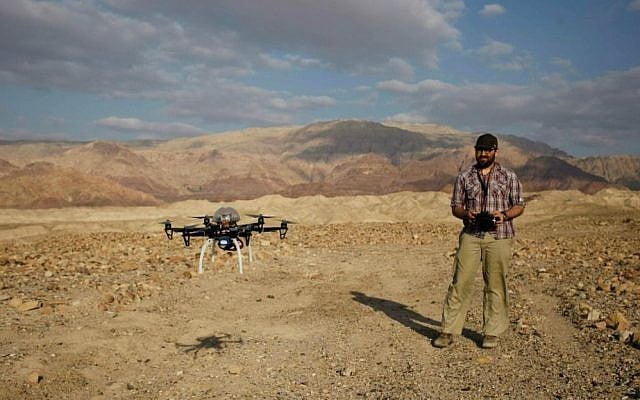 In this photo taken Thursday, March 19, 2015, Chad Hill, an archaeologist at the University of Connecticut, operates a drone to survey looting at a 5,000-year-old cemetery known as Fifa in southern Jordan. (AP Photo/Sam McNeil)