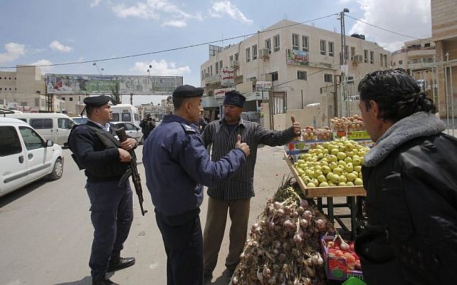 Palestinian policemen talk to a merchant in the West Bank town of Azariya, April 13, 2015. (photo credit: AP/Nasser Shiyoukhi) Palestinian policemen talk to a merchant in the West Bank town of Azariya, April 13, 2015. (photo credit: AP/Nasser Shiyoukhi)
