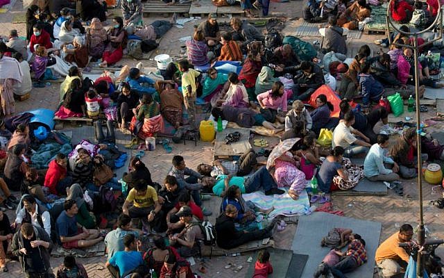 People gather on an open space for security reasons at Basantapur Durbar Square, damaged in Saturday’s earthquake, in Kathmandu, Nepal, Sunday, April 26, 2015. (AP Photo/Bernat Armangue)