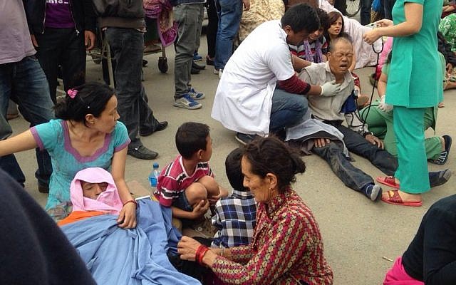An injured man receives treatment outside the Medicare Hospital in Kathmandu, Nepal, Saturday, April 25, 2015. (Photo credit: AP/ Niranjan Shrestha)