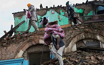Residents rescue items from debris of a house that was damaged in Saturday’s earthquake in Kathmandu, Nepal, Monday, April 27, 2015. (AP Photo/Bernat Armangue)
