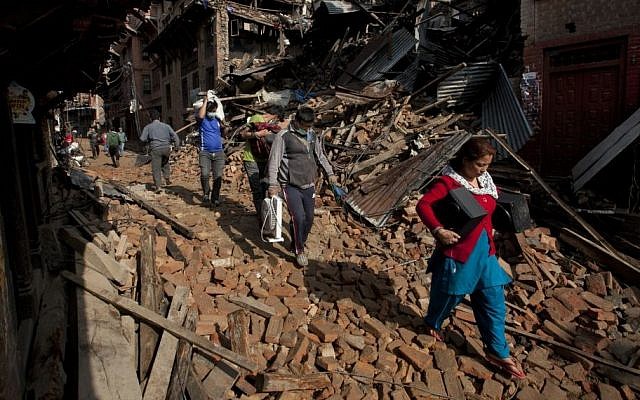 Nepalese residents carry belongings from their destroyed homes as they walk through debris of Saturday's earthquake, in Bhaktapur on the outskirts of Kathmandu, Nepal, Monday, April 27, 2015. (photo credit: AP/Niranjan Shrestha) Nepalese residents carry belongings from their destroyed homes as they walk through debris of Saturday's earthquake, in Bhaktapur on the outskirts of Kathmandu, Nepal, Monday, April 27, 2015. (photo credit: AP/Niranjan Shrestha)