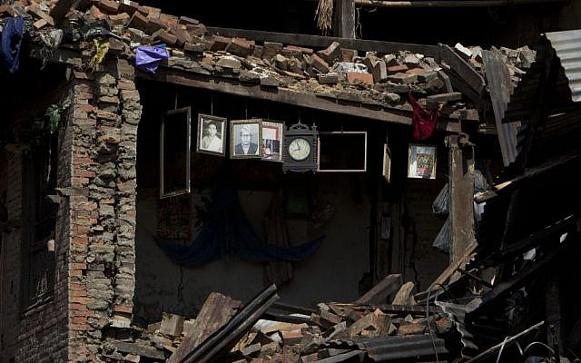 Portraits and a wall clock is seen hanging on the remains of a house damaged in Saturday's earthquake in Bhaktapur, on the outskirts of Kathmandu, Nepal, Monday, April 27, 2015. (photo credit: AP/Niranjan Shrestha) Portraits and a wall clock is seen hanging on the remains of a house damaged in Saturday's earthquake in Bhaktapur, on the outskirts of Kathmandu, Nepal, Monday, April 27, 2015. (photo credit: AP/Niranjan Shrestha)