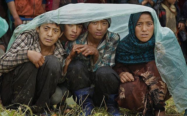 Villagers wait in the rain as an aid relief helicopter lands at their remote mountain village of Gumda, near the epicenter of Saturday's massive earthquake in the Gorkha District of Nepal, Wednesday, April 29, 2015. (photo credit: AP Photo/Wally Santana) Villagers wait in the rain as an aid relief helicopter lands at their remote mountain village of Gumda, near the epicenter of Saturday's massive earthquake in the Gorkha District of Nepal, Wednesday, April 29, 2015. (photo credit: AP Photo/Wally Santana)