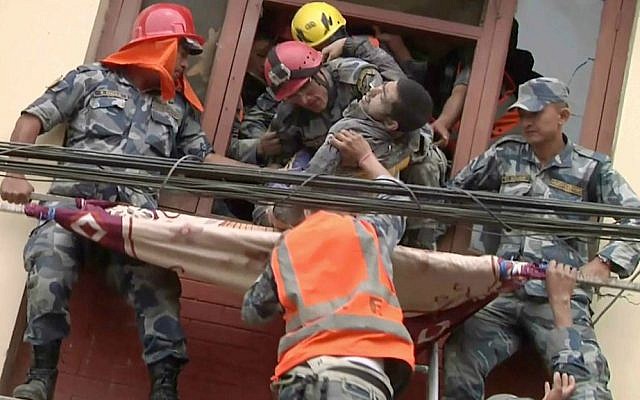 In this image made from video, rescue workers pull a survivor from an earthquake damaged building in Kathmandu, Nepal, Sunday, April 26, 2015. (APTN via AP)