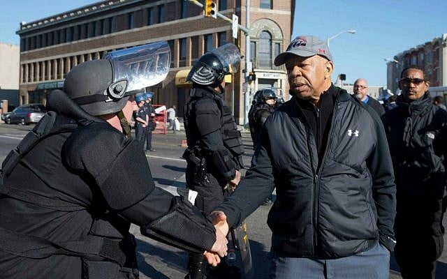 US Rep. Elijah Cummings (D-Maryland), shakes hands with a Maryland State Trooper Tuesday, April 28, 2015, in the aftermath of rioting following Monday's funeral for Freddie Gray, who died in police custody. (AP Photo/Matt Rourke)