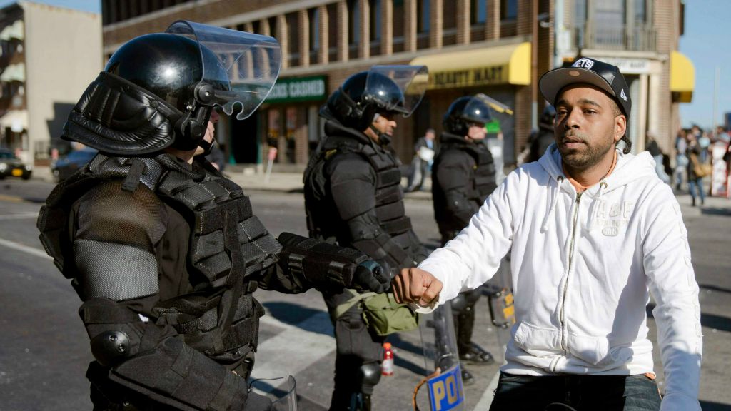 A man on a bicycle greets Maryland State Troopers Tuesday, April 28, 2015, in the aftermath of rioting following Monday's funeral for Freddie Gray, who died in police custody. (AP Photo/Matt Rourke) A man on a bicycle greets Maryland State Troopers Tuesday, April 28, 2015, in the aftermath of rioting following Monday's funeral for Freddie Gray, who died in police custody. (AP Photo/Matt Rourke)