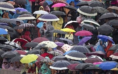 Faithful wait in the rain for Pope Francis' arrival at the Easter Mass in St. Peter's Square at the Vatican, Sunday, April 5, 2015. (photo credit: AP/Alessandra Tarantino)