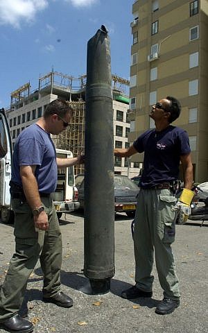 Israeli explosives experts inspect a Hezbollah rocket after it landed in the northern Israeli city of Haifa August 9, 2006. (photo credit: Max Yelinson /Flash90) 