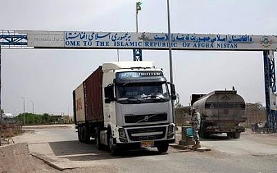 In this Monday, April 13, 2015 photo, an Afghan border policeman mans a checkpoint, at the Afghanistan-Iranian border point on the outskirts of Islam Qala in Herat province, west of Kabul, Afghanistan. Around 25,000 Afghans a month are deported from Iran at Islam Qala, nicknamed “Zero Point” along with another 30,000 a month who cross returning home voluntarily, a sign of Tehran’s efforts to control the huge numbers of Afghans who flock to their neighbor. Iran has long been an outlet for Afghans, either searching for work to escape poverty or seeking refuge from their country’s chronic wars and instability. (Photo credit: AP Photo/Massoud Hossaini)