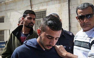 Niv Asraf (C) and his friend Eran Negauker (L), 22-year-olds from Beersheba, are seen at the Jerusalem Magistrate's Court for remand extension on April 3, 2015, a morning after Asraf was found in Kiryat Arba after being falsely reported as missing (Hadas Parush/ Flash90)