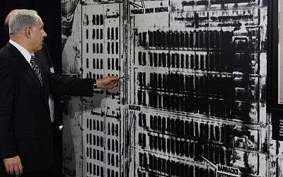 Prime Minister Benjamin Netanyahu in Berlin on August 27, 2009, examining a US military aerial photo of Auschwitz-Birkenau (photo credit: AP/Rainer Jensen, pool)