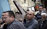 Catholic worshipers carry a wooden cross during the Good Friday procession along the Via Dolorosa (Way of Suffering) on April 3, 2015 in Jerusalem's Old City (photo credit: AFP/Thomas Coex)