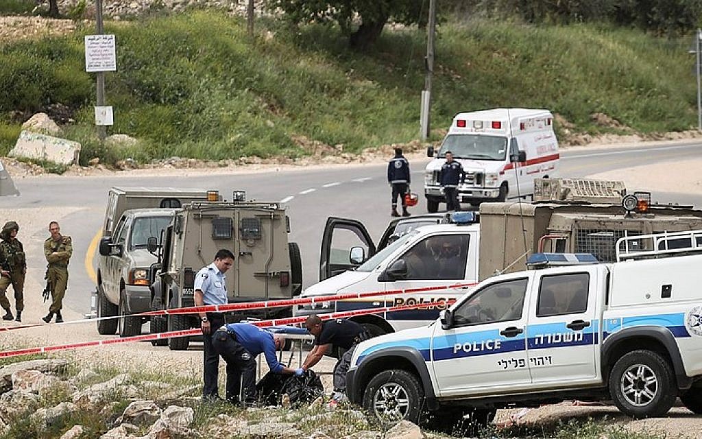 Security forces evacuate the body of a Palestinian attacker who stabbed two Israeli soldiers near Maaleh Nevona in the Binyamin area of the West Bank, on April 8, 2015. (Photo credit: Hadas Parush/FLASH90)