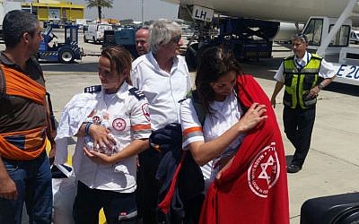 Illustrative: A Magen David Adom paramedic holding a newborn baby born to a surrogate mother in Nepal, on April 28 2015. (Courtesy Magen David Adom)