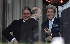 From left: British Foreign Secretary Philip Hammond, Senior Director at the National Security Council Robert Malley and US Secretary of State John Kerry stand on the terrace of the Beau-Rivage Palace hotel while taking a break during an extended round of talks on April 1, 2015 in Lausanne (photo credit: AFP/ FABRICE COFFRINI)