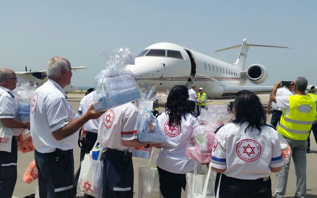 Magen David Adom paramedics wait on the tarmac as a plane that brought five babies born in Nepal to surrogate mothers lands in Israel, on Monday, April 27 2015. (Photo credit: Courtesy MDA)