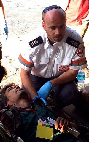 Ilan Klein, a paramedic with MDA, treat local residents injured in the Nepal earthquake on Sunday in Kathmandu. (photo courtesy: MDA) 