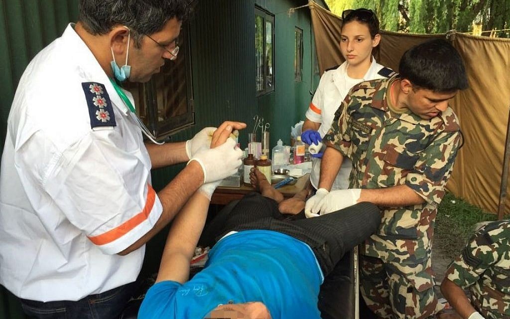 A photo released by Magen David Adom on Tuesday, April 28 2015 shows a Magen David Adom paramedic treating a patient in Kathmandu, Nepal, after the earthquake that hit the country last week. (Photo credit: Courtesy Magen David Adom)