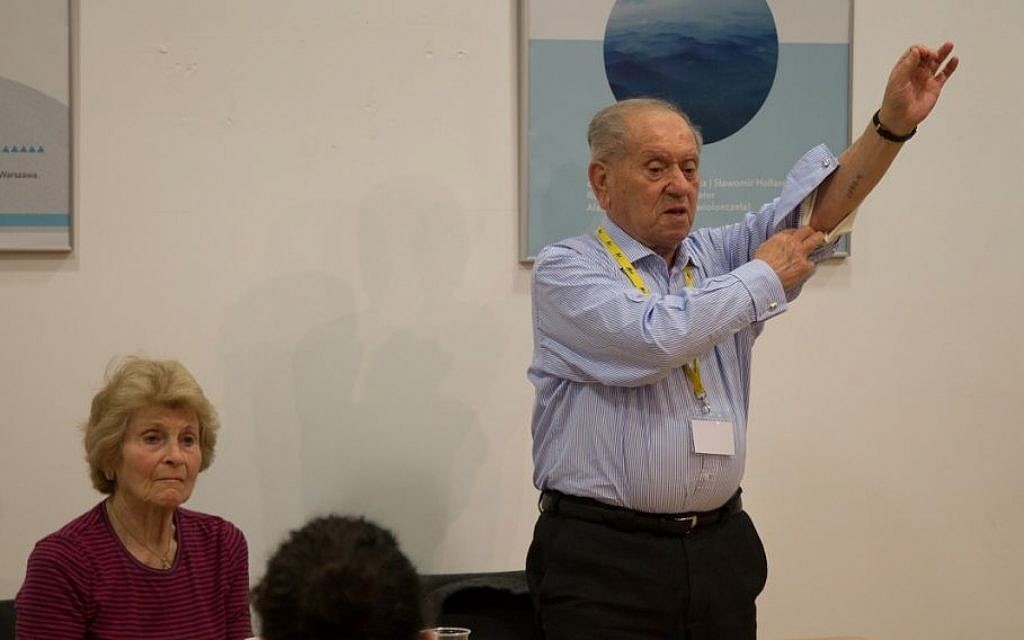 Survivor Arik Hersh, 88,  who now lives in Liverpool, shows his camp tattoo to British Jews at the Kraków JCC. (Photo credit: Sam Churchill Photography)