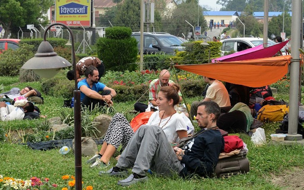 Tourists wait outside Kathmandu airport following an earthquake in the Nepalese capital Kathmandu on April 26, 2015. (photo credit: AFP PHOTO / PRAKASH MATHEMA)