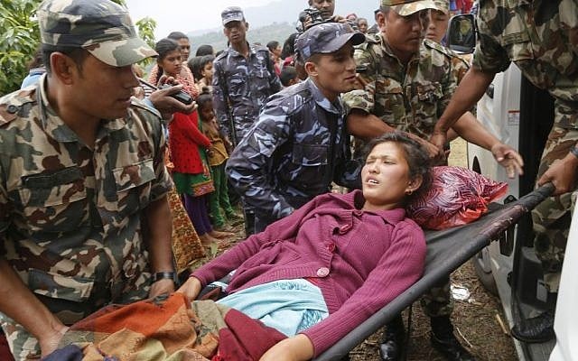 Sita Karka, suffering two broken legs from Saturday's massive earthquake, is assisted into an ambulance by Nepalese soldiers and police after arriving by helicopter from the heavily-damaged Ranachour village at a landing zone in the town of Gorkha, Nepal, Tuesday, April 28, 2015. (Photo credit: AP/Wally Santana) Sita Karka, suffering two broken legs from Saturday's massive earthquake, is assisted into an ambulance by Nepalese soldiers and police after arriving by helicopter from the heavily-damaged Ranachour village at a landing zone in the town of Gorkha, Nepal, Tuesday, April 28, 2015. (Photo credit: AP/Wally Santana)