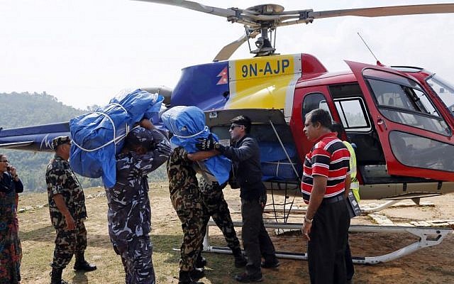A helicopter is loaded with supplies at a relief staging area of landing zone near Saturday's massive earthquake's epicenter in the town of Gorkha, Nepal, Tuesday, April 28, 2015. (Photo credit: AP/Wally Santana)
