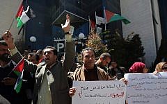Palestinians shout slogans as they hold banners during a gathering in solidarity with the Palestinians living in Syria's Yarmouk camp, on April 5, 2015 outside Palestinian Liberation Organization (PLO) headquarters in Ramallah, the West Bank (photo credit: AFP/ ABBAS MOMANI)