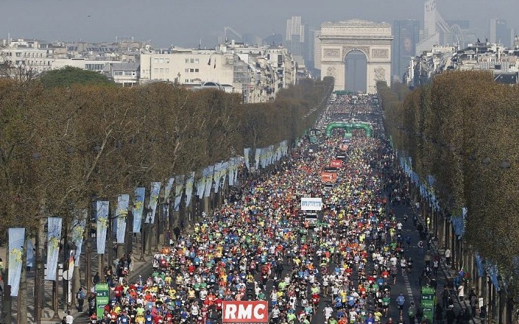 Competitors in the 39th Paris Marathon run down the Champs Elysees in Paris on April 12, 2015. (Photo credit: Thomas Samson/AFP)