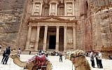 Camels used for transporting visitors wait for tourists at the ancient city of Petra in Jordan on March 25, 2015. (Photo credit: AFP / KHALIL MAZRAAWI)