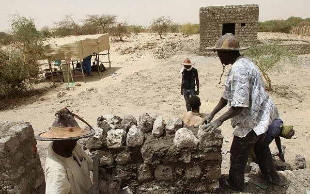 People work on the reconstruction of the mausoleums in the Three Saints cemetery on April 8, 2015 in Timbuktu, northern Mali. (Photo credit: AFP/SEBASTIEN RIEUSSEC) People work on the reconstruction of the mausoleums in the Three Saints cemetery on April 8, 2015 in Timbuktu, northern Mali. (Photo credit: AFP/SEBASTIEN RIEUSSEC)