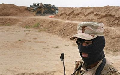 In this Monday, April 20, 2015 photo, a Sunni fighter stands on the frontline, just a kilometer away from the Sunni extremists of the Islamic State group, in northern Iraq. The Sunni fighters, part of the al-Lehib tribe, are fighting some of their own tribe members who joined the Islamic State group. (Photo credit: AP/Bram Janssen)