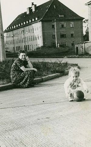 Dina Lichtman playing at the Bergen-Belsen DP camp as her mother Bella Cypris looks on, 1949. (photo credit: courtesy of Dina Lichtman) Dina Lichtman playing at the Bergen-Belsen DP camp as her mother Bella Cypris looks on, 1949. (photo credit: courtesy of Dina Lichtman)