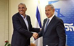 Kulanu party leader Moshe Kahlon and Prime Minister Benjamin Netanyahu shake hands after signing a coalition deal on April 29, 2015. (photo credit: courtesy of Likud party)