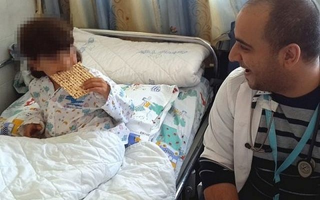 A Syrian boy hospitalized in Israel has his first taste of matzah on Tuesday, April 7, 2015 (courtesy Ziv Hospital)