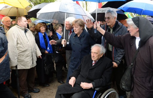 German Chancellor Angela Merkel (C) walks with Holocaust survivor Max Mannheimer (3th R) at former Nazi concentration camp of Dachau, southwestern Germany, during a ceremony to mark 70 years since it was liberated by US forces on May 3, 2015. (photo credit: AFP PHOTO / CHRISTOF STACHE)