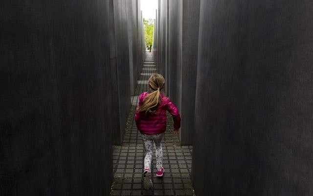 A girl plays hide and seek in the Memorial to the Murdered Jews of Europe, the Holocaust Memorial, in Berlin on April 30, 2015. (photo credit: AFP/JOHN MACDOUGALL)