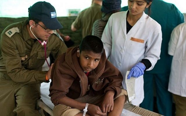 Illustrative: A Nepalese boy is treated by an Israeli army medic at the Israeli field hospital in Kathmandu on April 30, 2015. (AFP/ MENAHEM KAHANA) Illustrative: A Nepalese boy is treated by an Israeli army medic at the Israeli field hospital in Kathmandu on April 30, 2015. (AFP/ MENAHEM KAHANA)