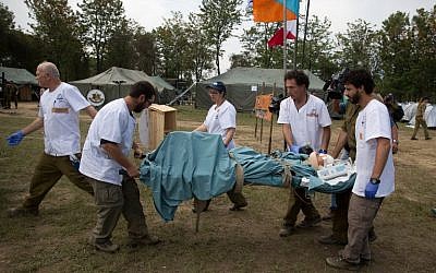An Israeli army medic team carry Krishna Khadka, who was pulled out alive from a collapsed building, to a more thorough medical check at the Israeli field hospital in Kathmandu on May 1 2015. (photo credit: AFP/MENAHEM KAHANA)