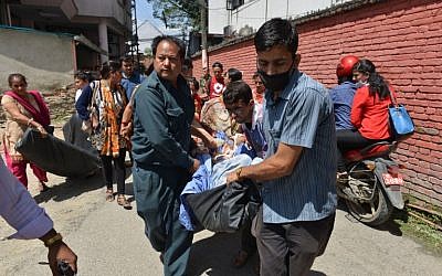 Nepalese patients are carried out of a hospital building after a 7.3-magnitude earthquake hit the country, in Kathmandu on Tuesday, May 12, 2015 (AFP PHOTO / PRAKASH MATHEMA)