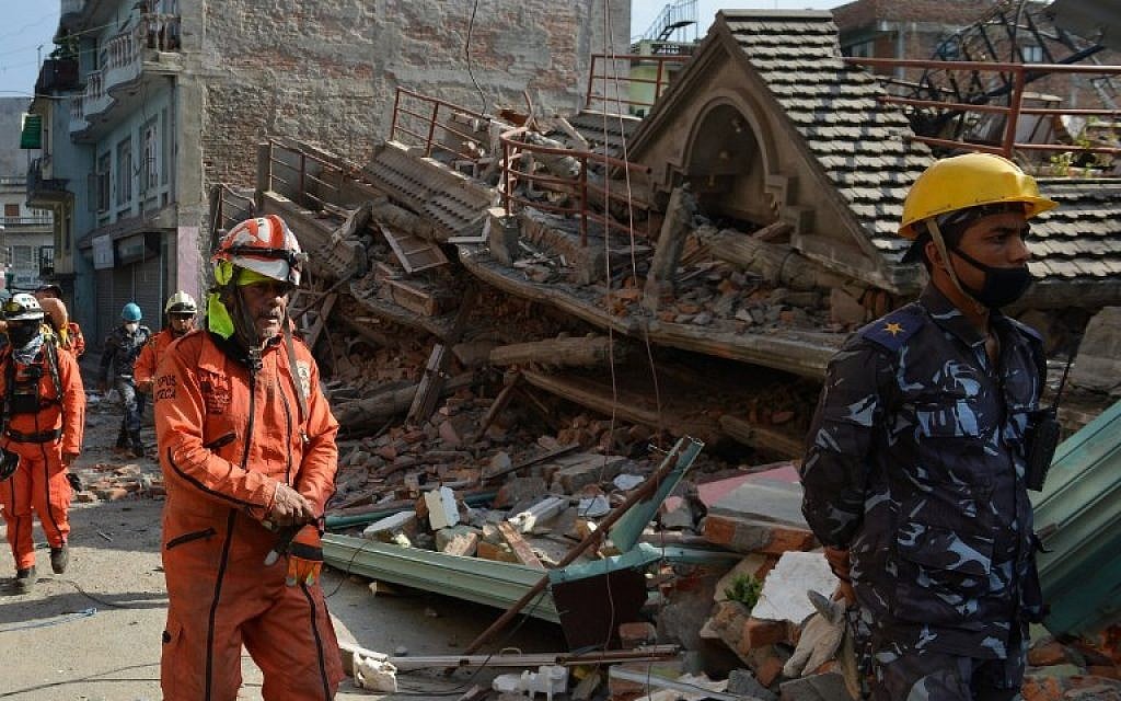 Rescue team officials arrive to search for survivors at a collapsed house in Kathmandu May 12, 2015, after an earthquake struck. (photo credit: AFP/PRAKASH MATHEMA)