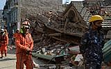 Rescue team officials arrive to search for survivors at a collapsed house in Kathmandu May 12, 2015, after an earthquake struck. (photo credit: AFP/PRAKASH MATHEMA)