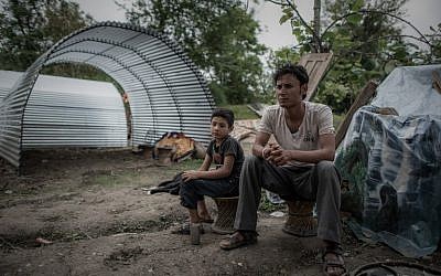 Earthquake survivor Navaraj Bista (R) and his son sit in front of their new shelter in the outskirts of Kathmandu following April 25's devastating 7.8 magnitude earthquake. May 8, 2015 (AFP/Philippe Lopez)